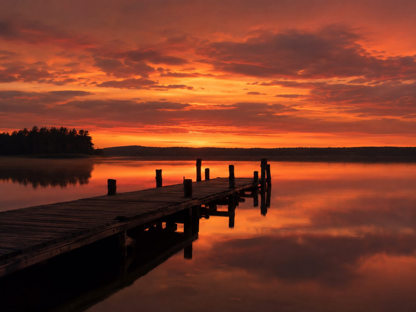 Zachód słońca nad jeziorem Mazury, czerwone niebo, sylwetka pomostu